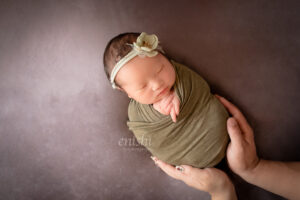 ニューボーンフォト女の子、パパとママの手に包まれて。